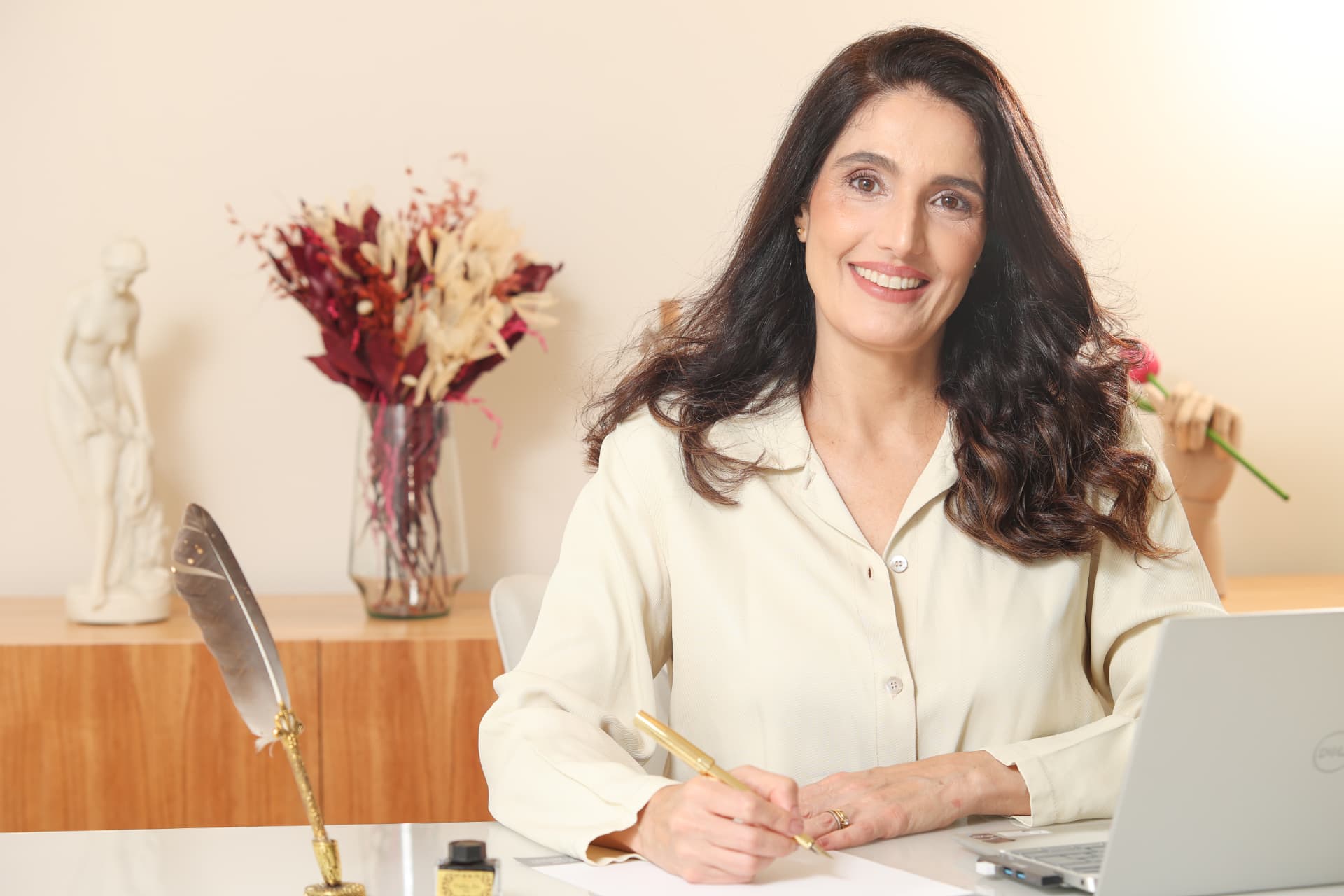 Dra. Vanessa Rajo à mesa de trabalho do consultório
